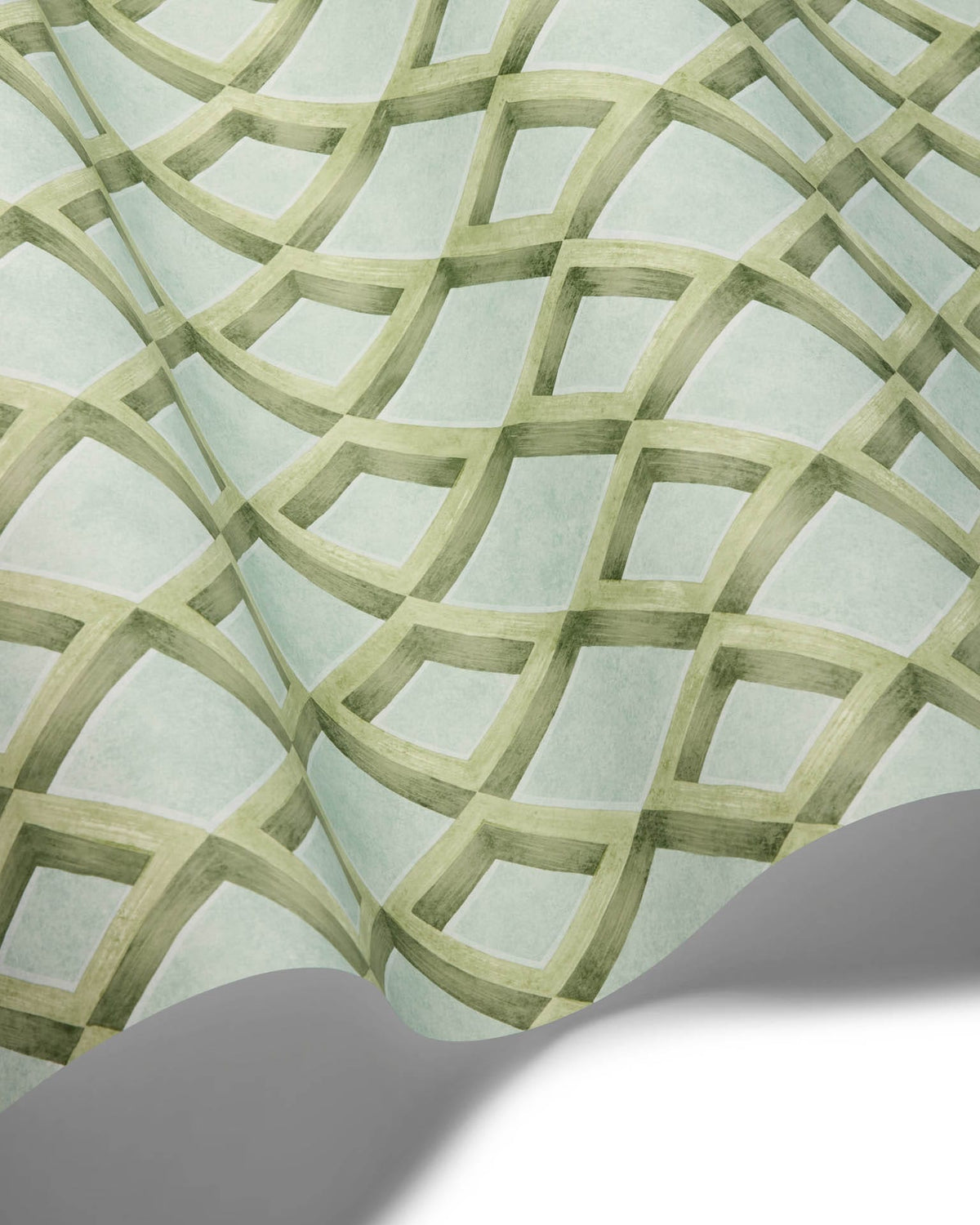 A close-up of a patterned surface with a light mint green background and a repeating geometric lattice design in muted sage green. A folded corner reveals a white underside, suggesting this is a sheet of wallpaper, fabric, or wrapping paper.